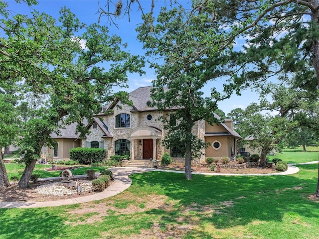 106 Elm Ct, Bastrop, TX 78602 - french country home featuring stone siding, a front yard, and stucco siding