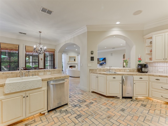 106 Elm Ct, Bastrop, TX 78602 - kitchen with stainless steel dishwasher, tasteful backsplash, brick flooring, cream cabinets, and recessed lighting