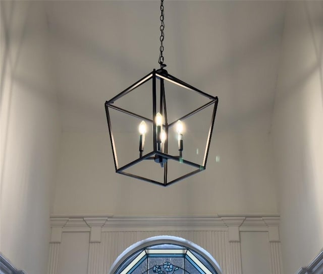 details with an inviting chandelier and wainscoting