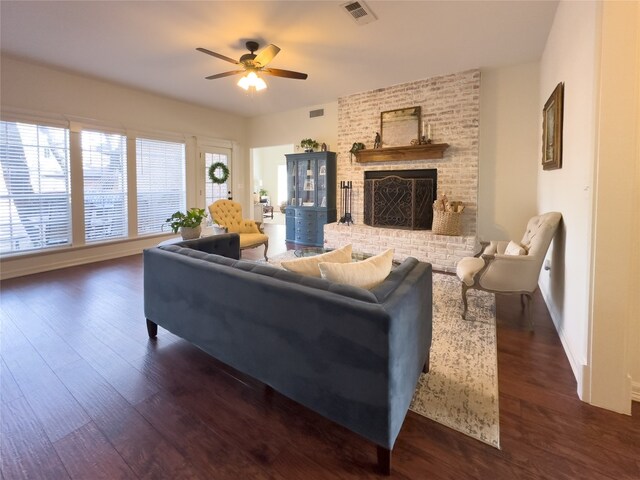 living room with visible vents, wood finished floors, a fireplace, and a ceiling fan