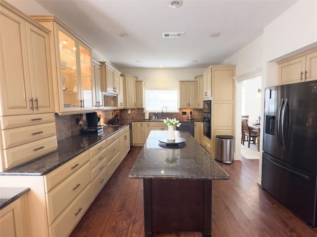 kitchen with cream cabinets, visible vents, and black appliances