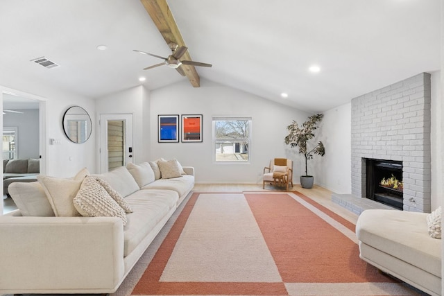 living room featuring vaulted ceiling with beams, a brick fireplace, visible vents, ceiling fan, and recessed lighting