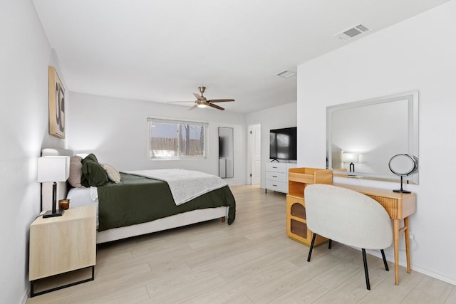 bedroom featuring visible vents, light wood-style floors, and a ceiling fan
