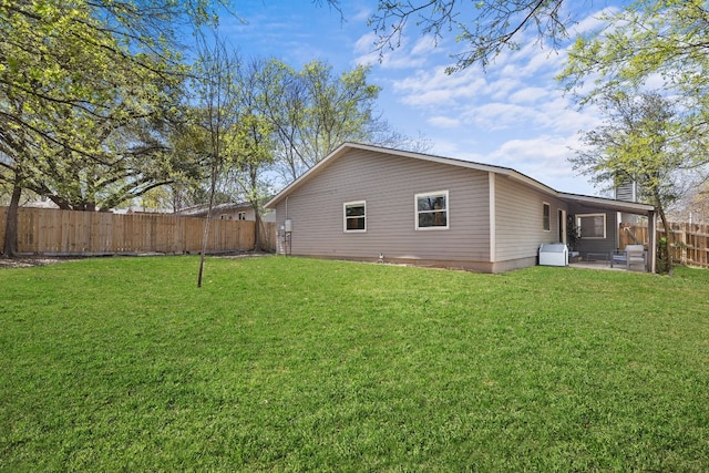 rear view of property with a fenced backyard, a lawn, and a patio area