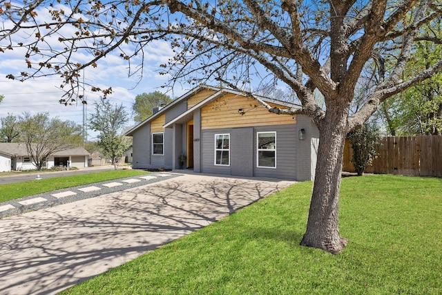 view of front facade featuring fence, a front lawn, and concrete driveway