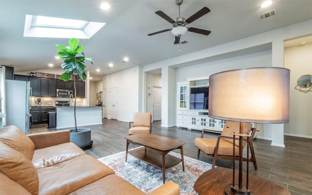 20700 Deep Crk, Lago Vista, TX 78645 - living room with dark wood-style flooring, vaulted ceiling, ceiling fan, a skylight, and baseboards