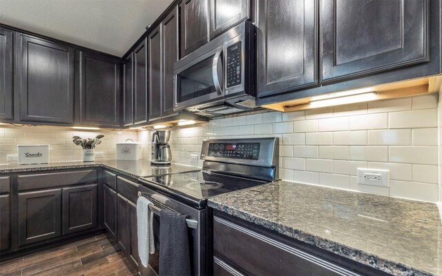 20700 Deep Crk, Lago Vista, TX 78645 - kitchen featuring stainless steel appliances, dark wood finished floors, dark stone countertops, and tasteful backsplash