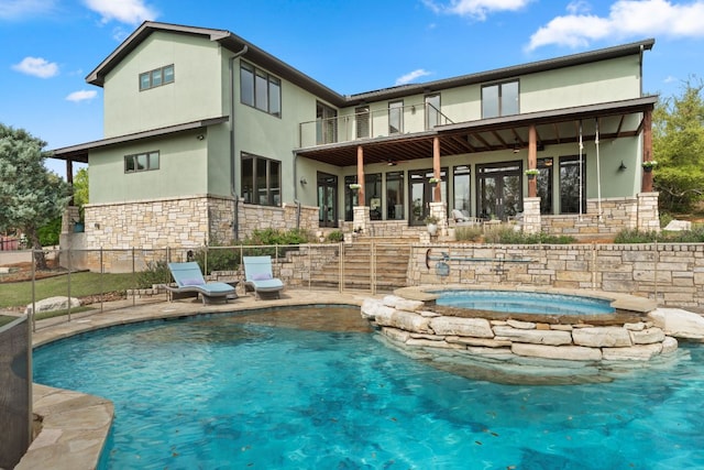 4004 Cloudy Ridge Rd, Austin, TX 78734 - rear view of property with stone siding, a balcony, an in-ground hot tub, and stucco siding