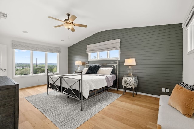 4004 Cloudy Ridge Rd, Austin, TX 78734 - bedroom featuring multiple windows, lofted ceiling, wooden walls, light wood finished floors, and a ceiling fan
