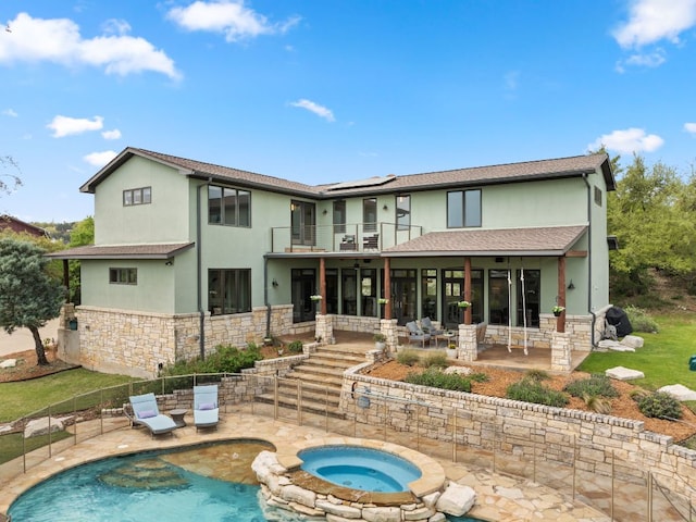 4004 Cloudy Ridge Rd, Austin, TX 78734 - rear view of property featuring a balcony, a patio area, stone siding, stucco siding, and an in-ground hot tub