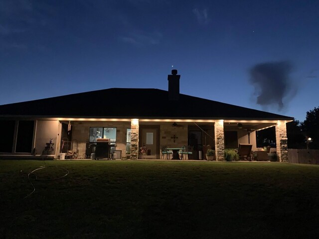 2129 Woodland Bend Rd, Salado, TX 76571 - rear view of property featuring stone siding, a lawn, a patio area, and a chimney