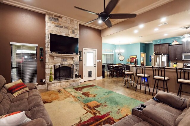 2129 Woodland Bend Rd, Salado, TX 76571 - living room featuring ceiling fan with notable chandelier, baseboards, a fireplace, and visible vents