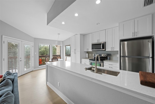 1406 Windsor Rd Unit 301, Austin, TX 78703 - kitchen with white cabinets, visible vents, stainless steel appliances, a sink, and light wood-type flooring