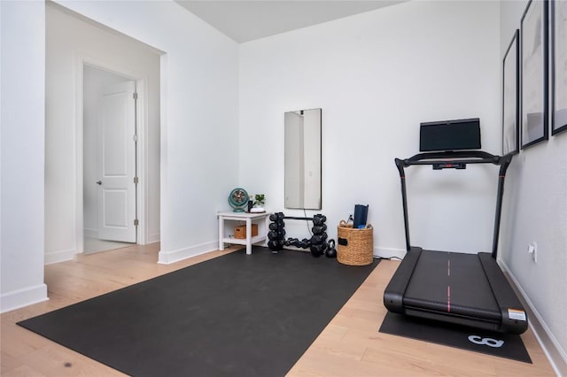 exercise room featuring baseboards and wood finished floors