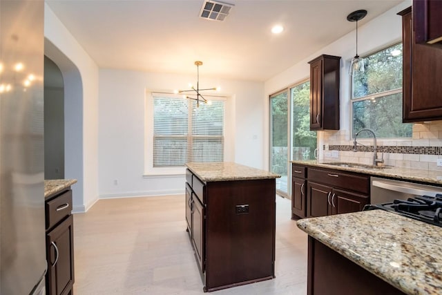 6108 Whipple Way, Austin, TX 78745 - kitchen with dark brown cabinetry, tasteful backsplash, a chandelier, pendant lighting, and recessed lighting