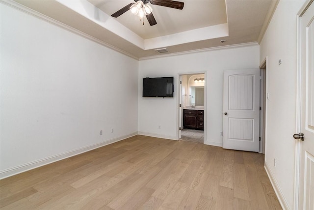 6108 Whipple Way, Austin, TX 78745 - unfurnished bedroom with a tray ceiling, light wood-style flooring, connected bathroom, and ceiling fan
