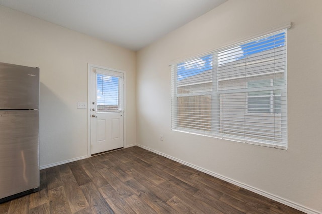 doorway with baseboards and wood finished floors
