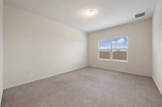 carpeted empty room featuring visible vents and baseboards