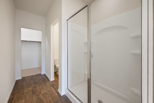 3603 Canaan Matthew Dr, Austin, TX 78725 - bathroom featuring a stall shower, wood finished floors, and a walk in closet