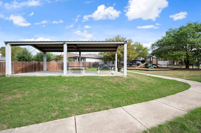 view of yard with a patio area, fence, and a playground