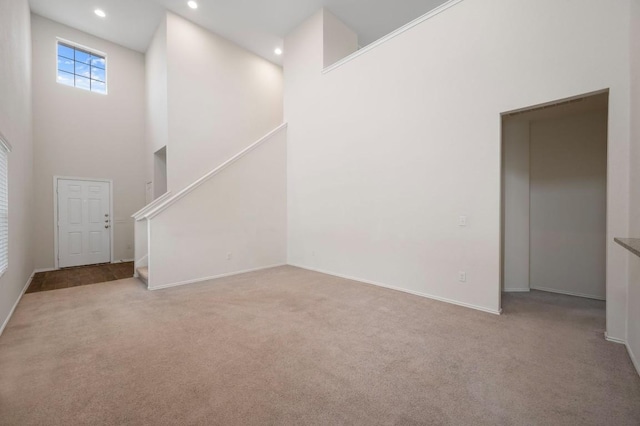 3603 Canaan Matthew Dr, Austin, TX 78725 - unfurnished living room featuring a towering ceiling, carpet floors, recessed lighting, and stairs