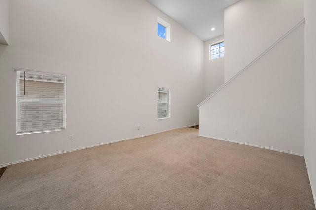 3603 Canaan Matthew Dr, Austin, TX 78725 - unfurnished living room with a towering ceiling, carpet flooring, stairway, and recessed lighting
