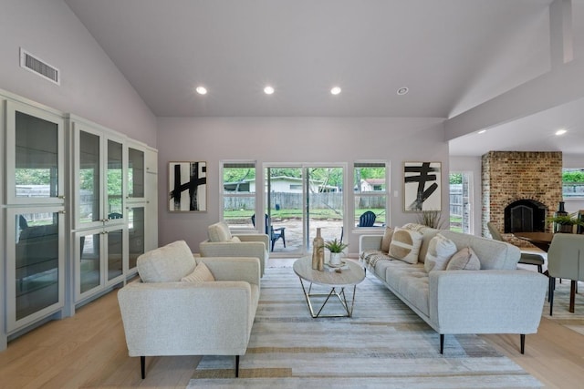 8702 Willowick Dr, Austin, TX 78759 - living room with healthy amount of natural light, light wood-style flooring, recessed lighting, a brick fireplace, and high vaulted ceiling
