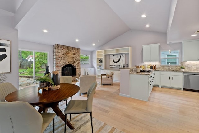 8702 Willowick Dr, Austin, TX 78759 - dining area featuring healthy amount of natural light, light wood-type flooring, lofted ceiling, a brick fireplace, and recessed lighting
