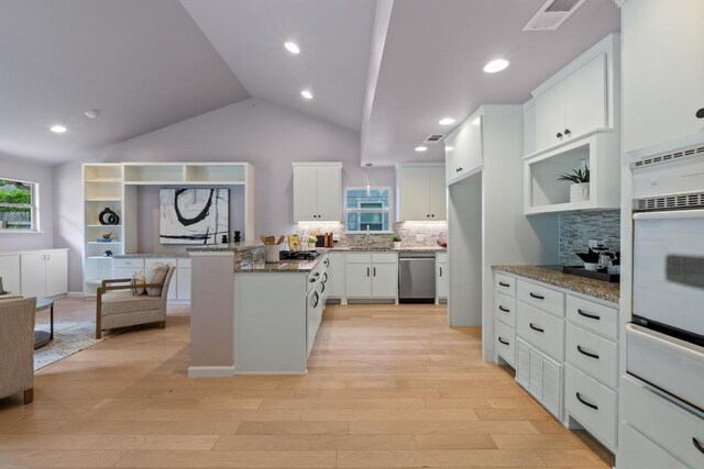8702 Willowick Dr, Austin, TX 78759 - kitchen with stainless steel dishwasher, a warming drawer, decorative backsplash, light wood-style floors, and vaulted ceiling