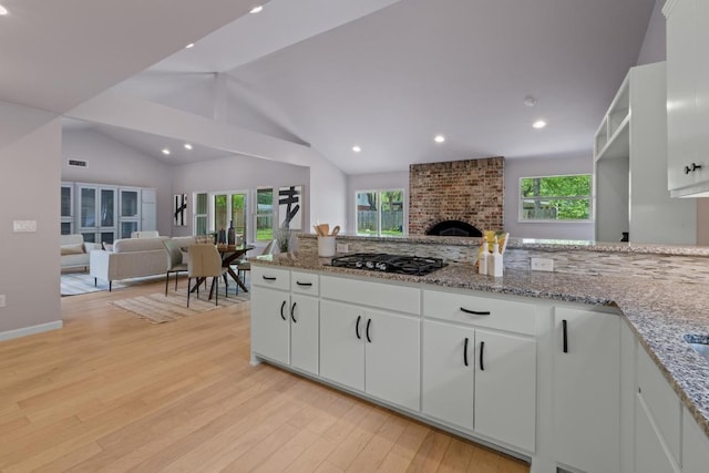 8702 Willowick Dr, Austin, TX 78759 - kitchen featuring black gas stovetop, open floor plan, light wood finished floors, plenty of natural light, and recessed lighting