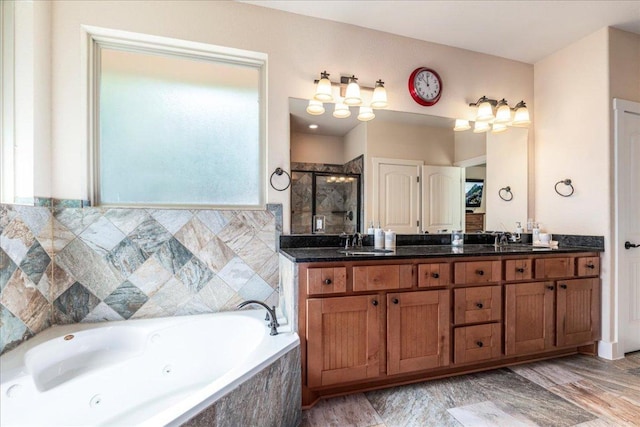 bathroom featuring a shower stall, a whirlpool tub, double vanity, and a sink