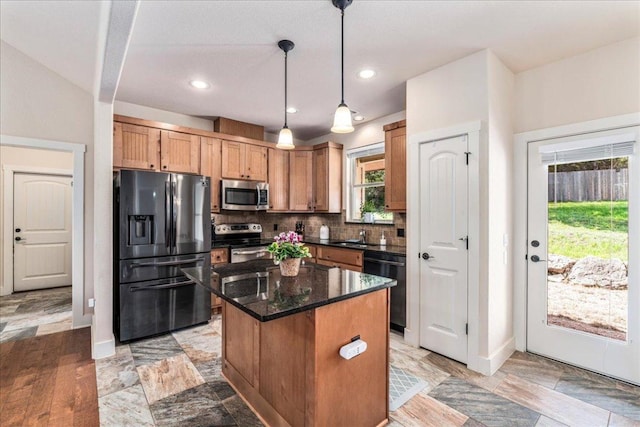 kitchen with decorative light fixtures, a center island, baseboards, backsplash, and black appliances