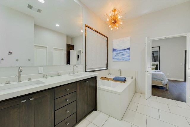 ensuite bathroom with a chandelier, tile patterned flooring, a tub to relax in, double vanity, and recessed lighting