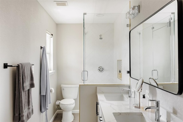 full bath with a sink, a stall shower, toilet, and visible vents
