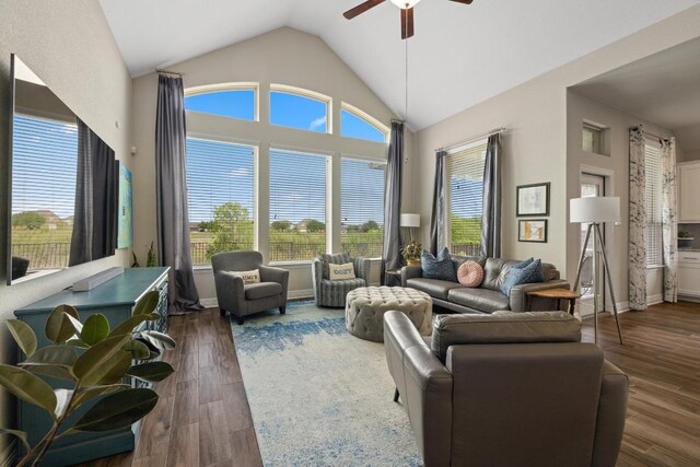 living area featuring dark wood-style flooring, a ceiling fan, and vaulted ceiling