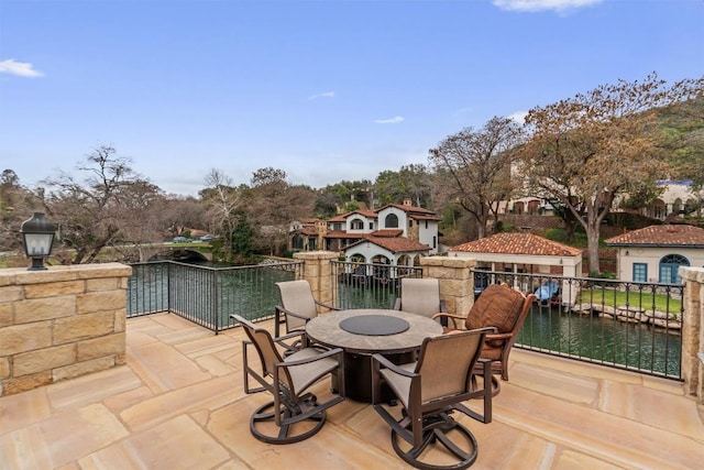 view of patio with outdoor dining area and a water view