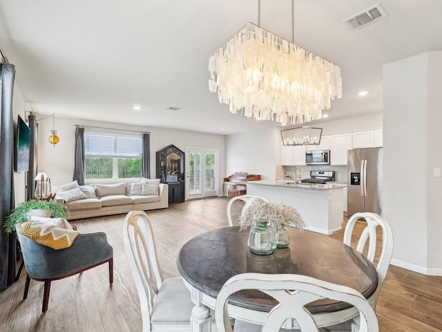 709 Bluffview Dr, Bastrop, TX 78602 - dining area featuring a chandelier, light wood-style flooring, recessed lighting, and baseboards