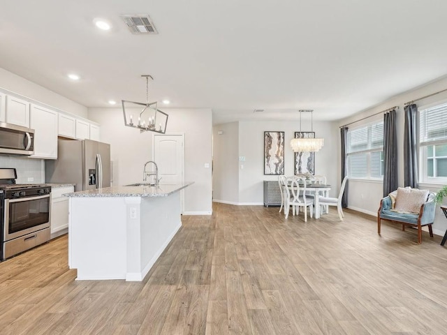 709 Bluffview Dr, Bastrop, TX 78602 - kitchen featuring appliances with stainless steel finishes, a chandelier, a sink, white cabinetry, and recessed lighting
