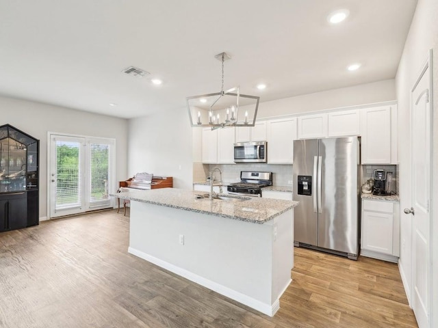 709 Bluffview Dr, Bastrop, TX 78602 - kitchen with appliances with stainless steel finishes, a sink, backsplash, a chandelier, and white cabinets