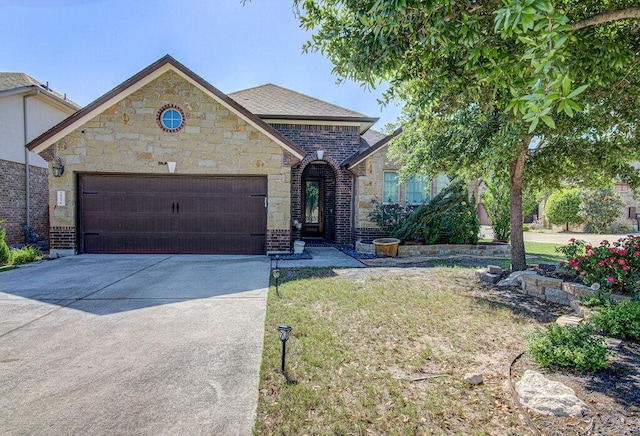 5617 Rio Chama Cv, Austin, TX 78738 - french country home with an attached garage, concrete driveway, a front yard, and brick siding