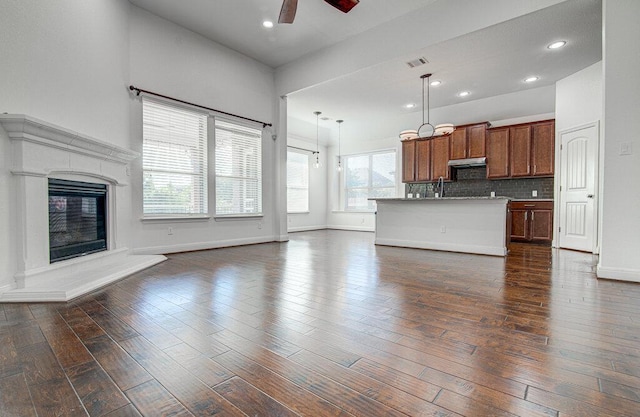 5617 Rio Chama Cv, Austin, TX 78738 - unfurnished living room featuring a ceiling fan, dark wood finished floors, baseboards, a glass covered fireplace, and recessed lighting