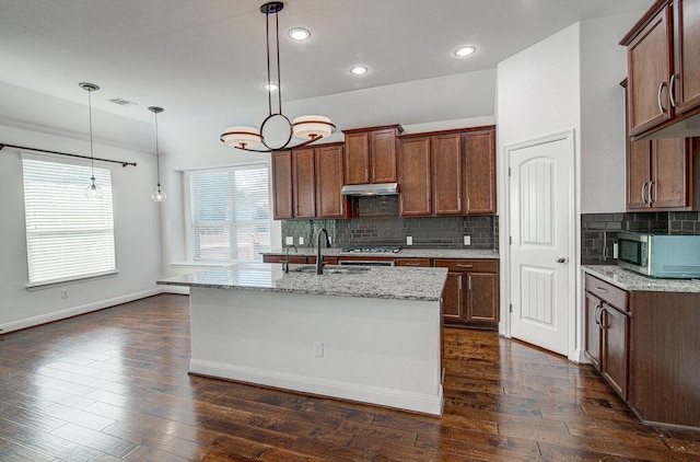 5617 Rio Chama Cv, Austin, TX 78738 - kitchen with appliances with stainless steel finishes, a sink, under cabinet range hood, decorative backsplash, and light stone countertops