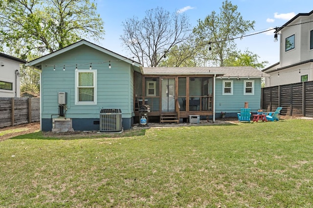 2008 Pequeno St, Austin, TX 78757 - back of house featuring a sunroom, a fenced backyard, central AC unit, and a lawn