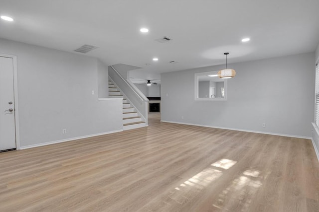 1434 Meadow Pkwy, San Marcos, TX 78666 - unfurnished living room with stairs, visible vents, recessed lighting, and light wood-type flooring