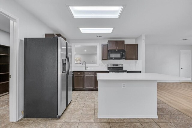 1434 Meadow Pkwy, San Marcos, TX 78666 - kitchen with a sink, light countertops, appliances with stainless steel finishes, and light tile patterned floors