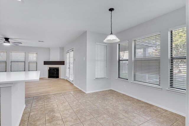 1434 Meadow Pkwy, San Marcos, TX 78666 - unfurnished living room with a ceiling fan, light tile patterned flooring, baseboards, and a fireplace