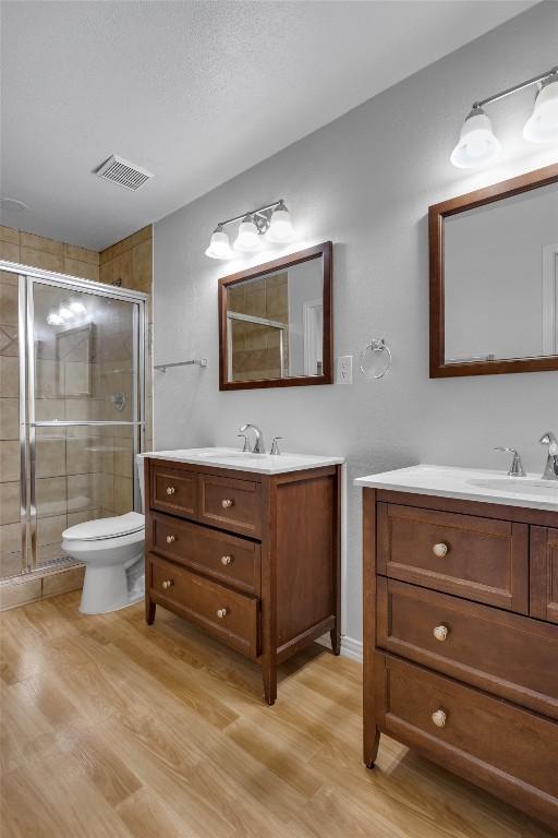 1434 Meadow Pkwy, San Marcos, TX 78666 - bathroom featuring visible vents, a stall shower, and wood finished floors