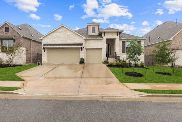 317 Independence Dr, Kyle, TX 78640 - view of front facade with stone siding, concrete driveway, a garage, and a front lawn