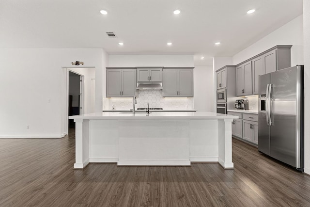 317 Independence Dr, Kyle, TX 78640 - kitchen with stainless steel appliances, gray cabinets, under cabinet range hood, dark wood-style flooring, and recessed lighting