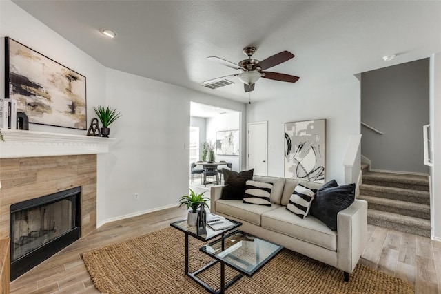 33 Verde Ranch Loop, Leander, TX 78641 - living area featuring ceiling fan, stairs, a tile fireplace, light wood-style floors, and baseboards